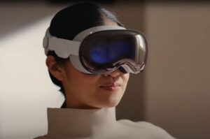 Seorang wanita memakai Apple Vision Pro, kacamata pintar AR terbaru dari Apple. Apple Vision Pro menampilkan layar AR yang imersif di depan mata penggunanya.